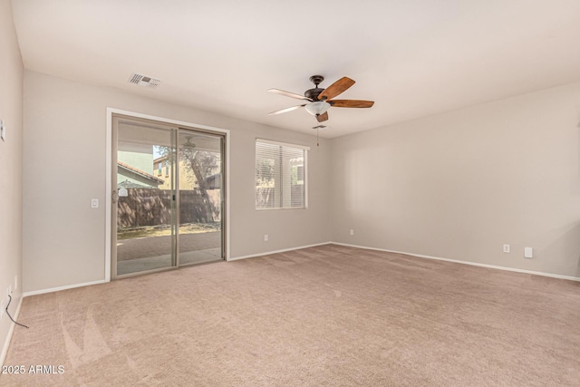 spare room with visible vents, ceiling fan, carpet flooring, and baseboards