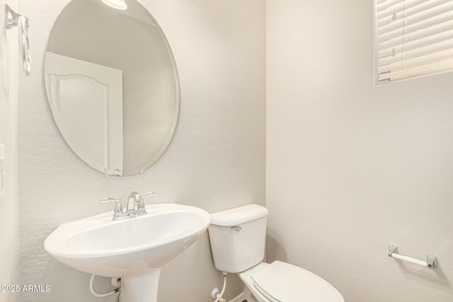half bath featuring a sink and toilet