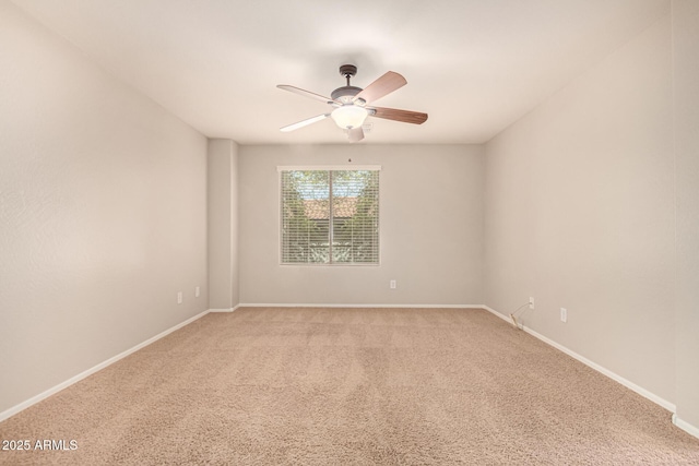 empty room featuring light colored carpet, baseboards, and a ceiling fan