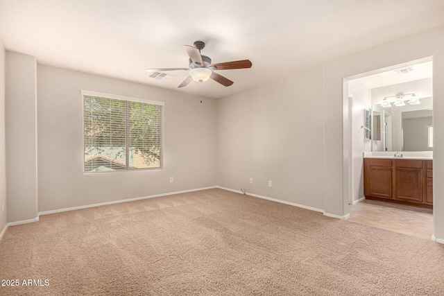unfurnished bedroom with visible vents, light colored carpet, baseboards, and ensuite bathroom