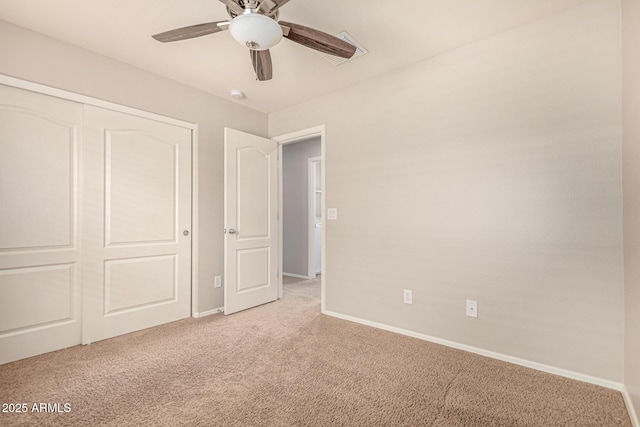 unfurnished bedroom featuring a closet, light colored carpet, baseboards, and ceiling fan