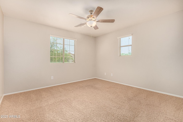 empty room featuring baseboards, a ceiling fan, carpet, and a wealth of natural light