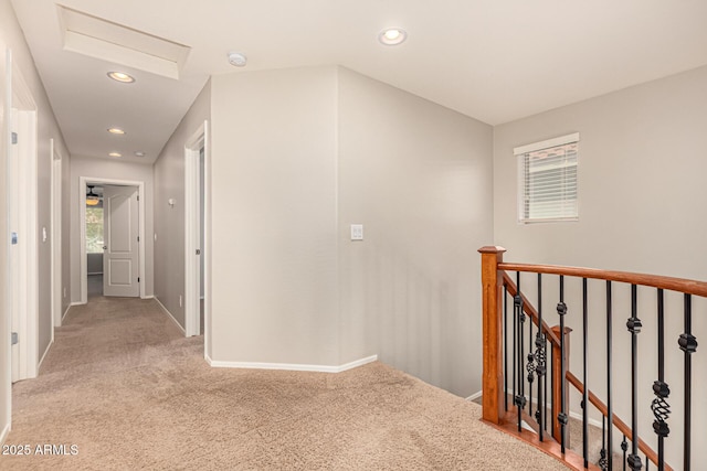 hall featuring recessed lighting, an upstairs landing, light colored carpet, and baseboards