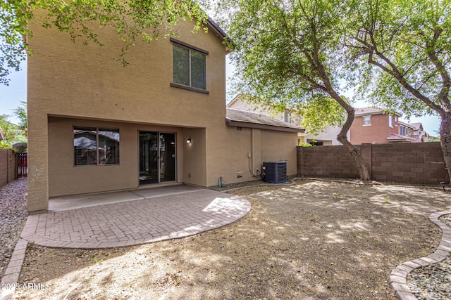 back of house with a patio area, stucco siding, central AC unit, and a fenced backyard