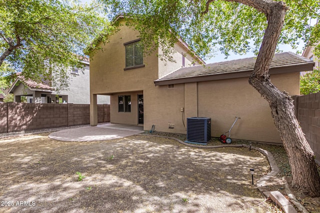 back of house with a patio area, stucco siding, fence, and central AC