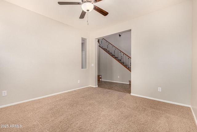 empty room with ceiling fan, stairway, carpet, and baseboards