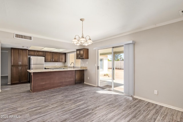 kitchen featuring visible vents, a chandelier, baseboards, dark wood-style floors, and freestanding refrigerator
