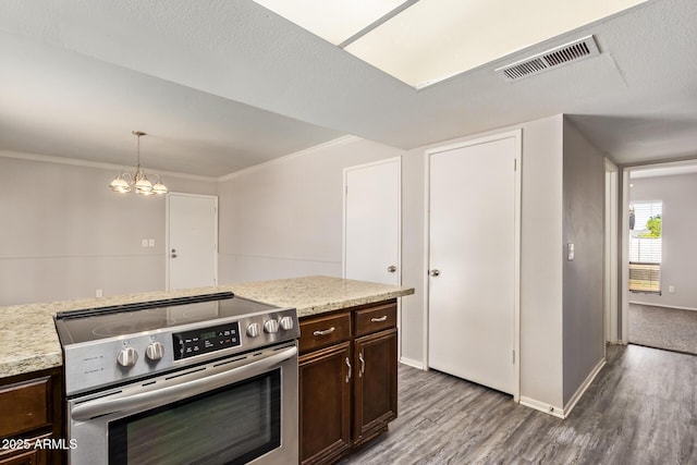 kitchen featuring dark brown cabinetry, wood finished floors, electric stove, visible vents, and ornamental molding