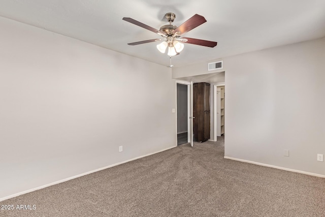 carpeted spare room with baseboards, visible vents, and a ceiling fan