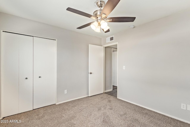unfurnished bedroom featuring baseboards, carpet floors, visible vents, a ceiling fan, and a closet