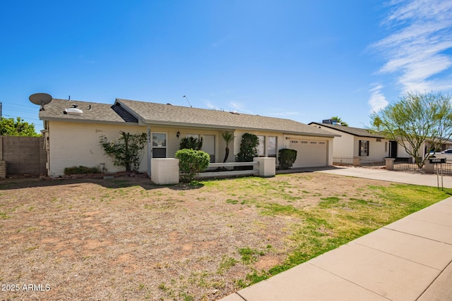 single story home featuring driveway, a garage, fence, and a shingled roof