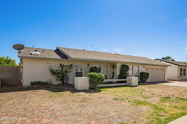 ranch-style house with fence, an attached garage, brick siding, driveway, and a shingled roof