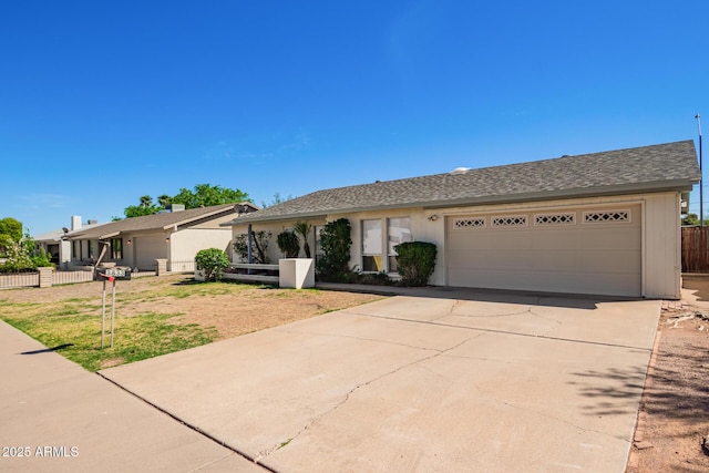 single story home featuring stucco siding, concrete driveway, a garage, and fence