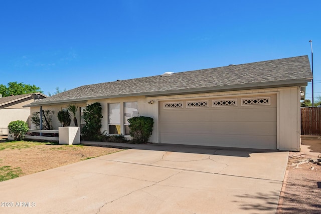 ranch-style house featuring driveway, a shingled roof, and fence