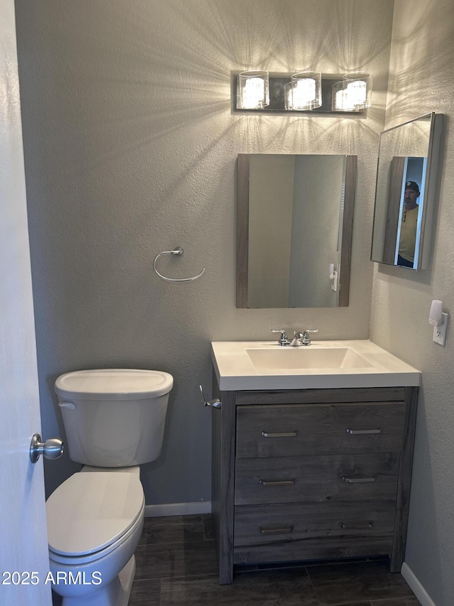 bathroom featuring vanity, toilet, and hardwood / wood-style floors