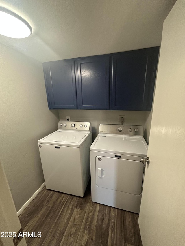 clothes washing area with cabinets, dark hardwood / wood-style flooring, and washer and clothes dryer