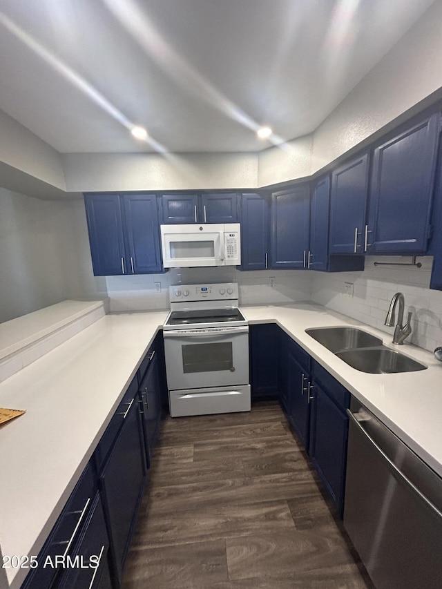 kitchen with blue cabinetry, sink, tasteful backsplash, dark hardwood / wood-style flooring, and white appliances