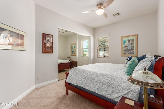 bedroom featuring a closet, ceiling fan, and light carpet