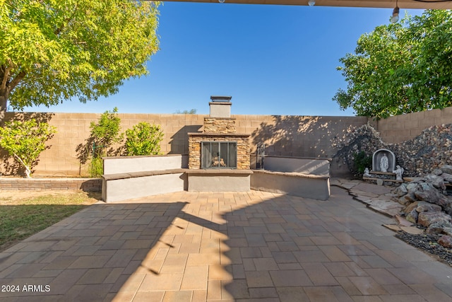 view of patio with an outdoor stone fireplace