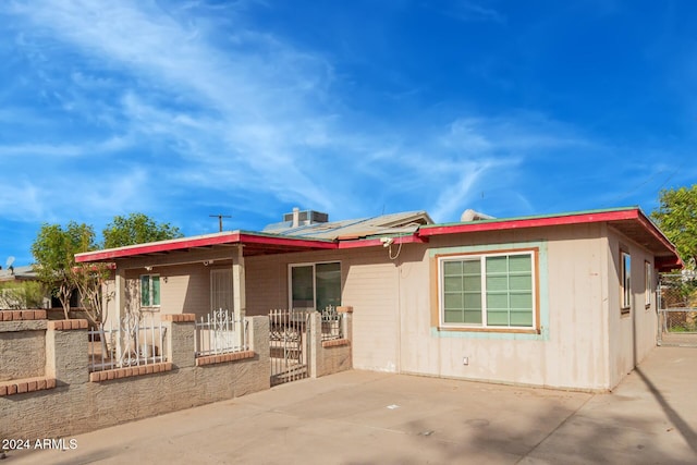 single story home featuring solar panels and a patio area