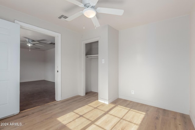 unfurnished bedroom with a closet, light hardwood / wood-style floors, and ceiling fan