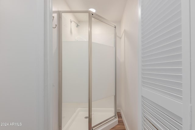 bathroom with wood-type flooring and walk in shower