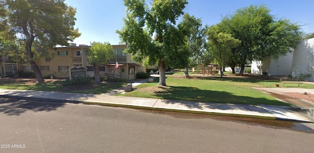 view of property's community featuring playground community and a yard