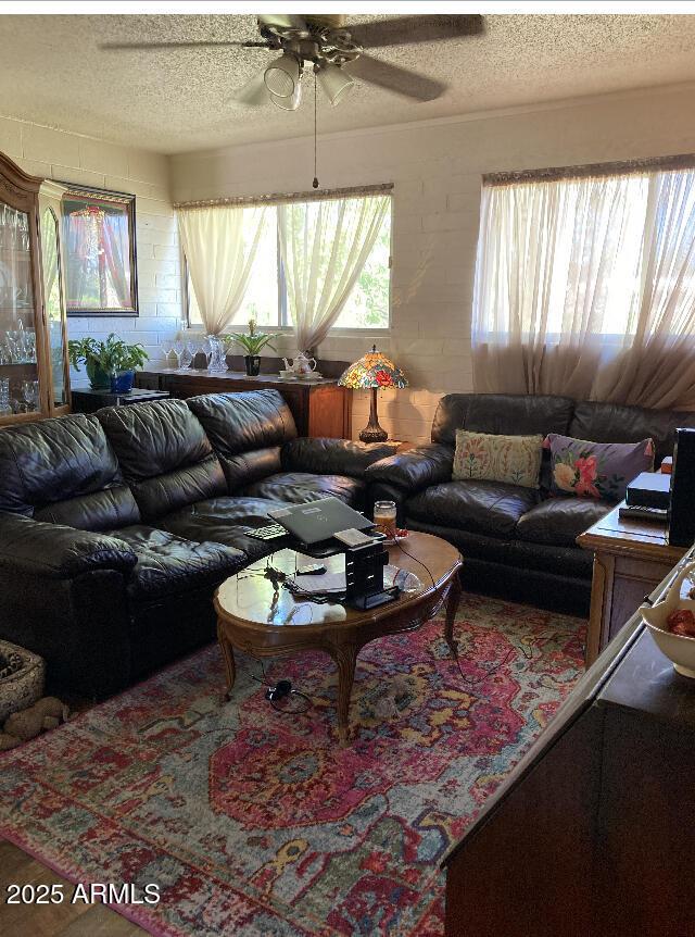 living area featuring a textured ceiling and ceiling fan