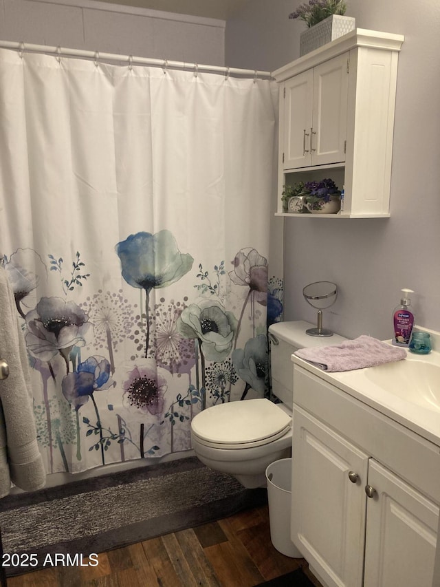 bathroom with vanity, toilet, wood finished floors, and a shower with shower curtain