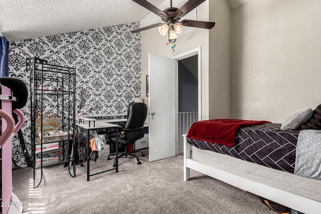 carpeted bedroom with a ceiling fan, a textured ceiling, and wallpapered walls