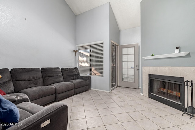 living room with baseboards, light tile patterned floors, lofted ceiling, and a fireplace