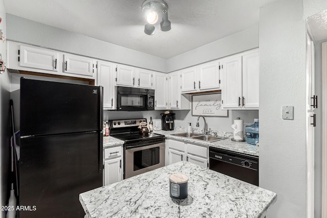 kitchen featuring a center island, a textured ceiling, white cabinets, a sink, and black appliances