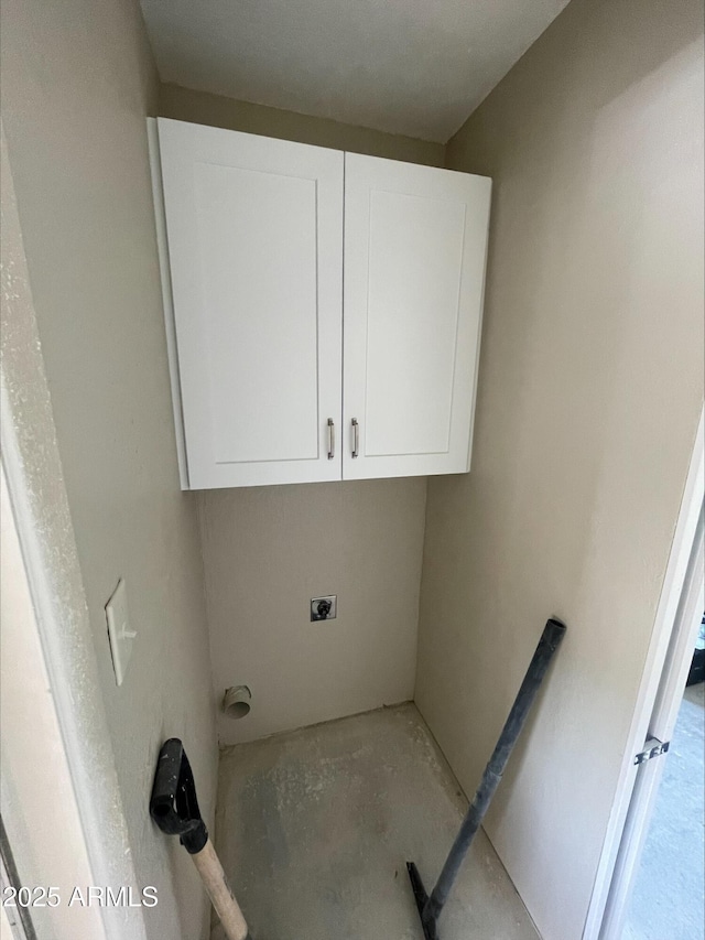 washroom featuring electric dryer hookup and cabinet space