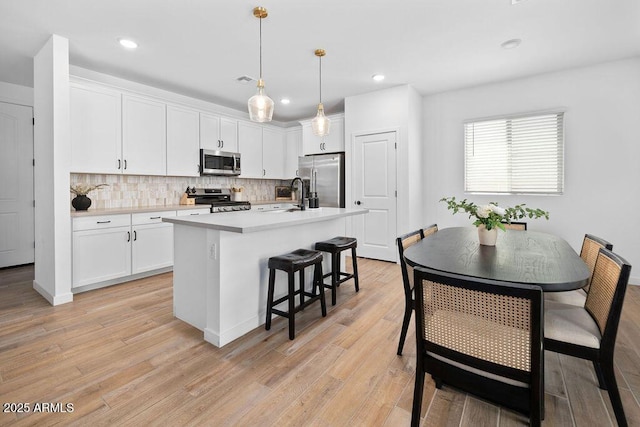 9230 E Scott Ave, Mesa, AZ 85212 - kitchen featuring appliances with stainless steel finishes, white cabinetry, decorative backsplash, an island with sink, and a sink