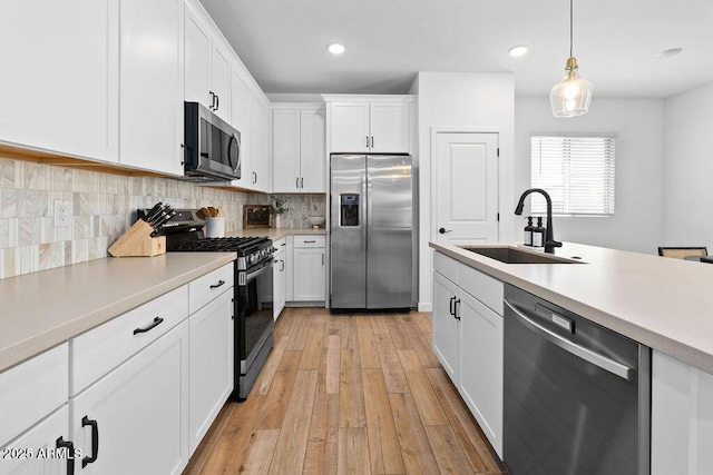 9230 E Scott Ave, Mesa, AZ 85212 - kitchen featuring stainless steel appliances, a sink, light countertops, light wood-type flooring, and decorative backsplash