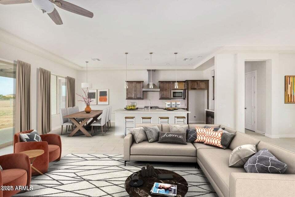 tiled living room with ceiling fan and ornamental molding