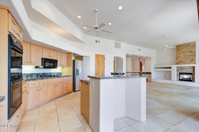 kitchen featuring light brown cabinets, light tile patterned floors, and black appliances