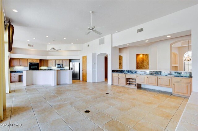 spare room with ceiling fan and light tile patterned floors