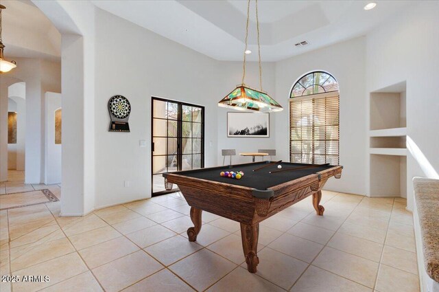 unfurnished living room featuring a high ceiling, light carpet, ceiling fan, and built in shelves