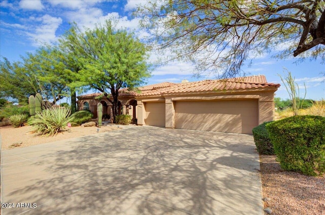 mediterranean / spanish home with a garage