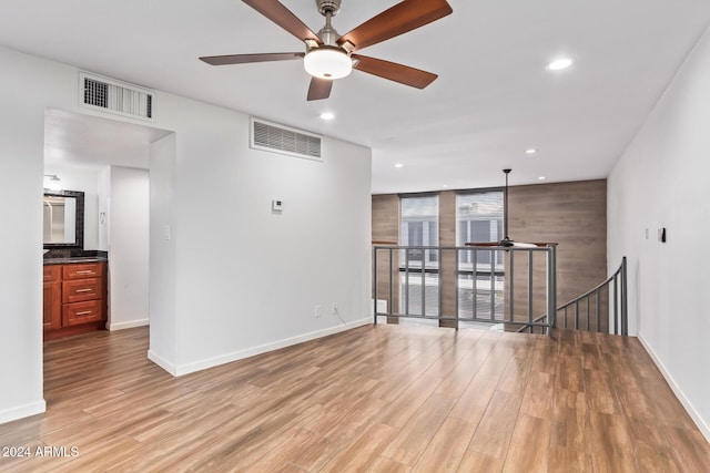 unfurnished living room featuring ceiling fan and light hardwood / wood-style floors