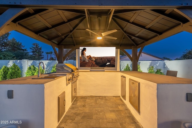 view of patio with a sink, exterior kitchen, a gazebo, and a fenced backyard