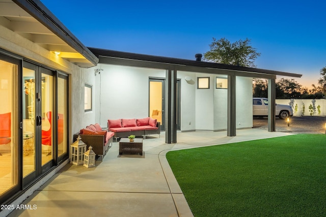 back of property featuring an outdoor hangout area, a patio, stucco siding, and a yard