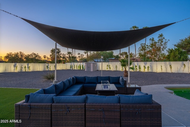 patio terrace at dusk featuring a fenced backyard and outdoor lounge area