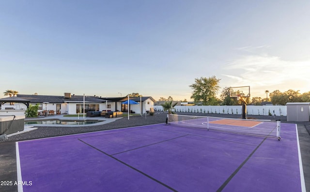 view of basketball court featuring community basketball court, fence, and a fenced in pool