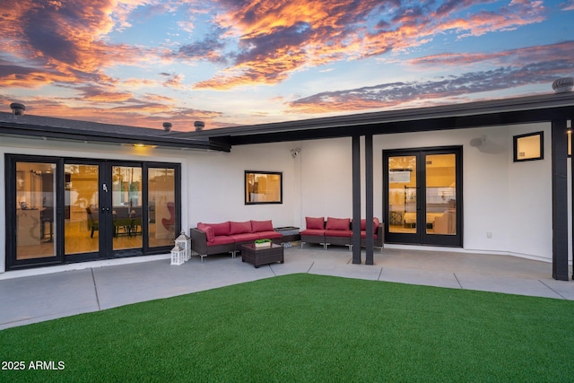 back of house featuring a lawn, stucco siding, an outdoor hangout area, and a patio