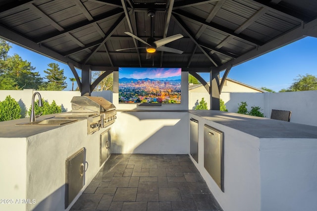 view of patio / terrace with fence, a sink, and a gazebo