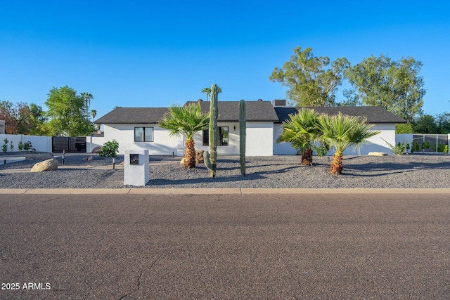 ranch-style home with stucco siding and fence