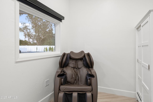 living area featuring baseboards and light wood-type flooring