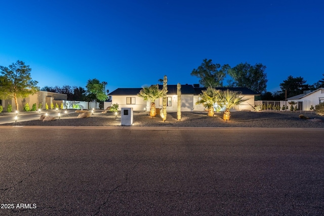 single story home featuring concrete driveway, fence, and stucco siding